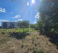 Plots - housing in Hronovce with a grassy area and a residential building in the background.