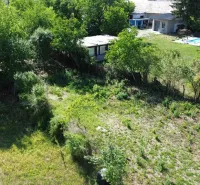 Greenery and land in Hronovce surrounded by trees, suitable for living.
