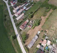 Aerial view of residential plots in Rakytník near the main road with adjacent buildings.