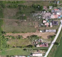 Aerial view of plots - housing in Rakytník, surrounded by greenery and buildings.