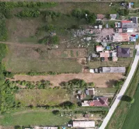 Aerial view of residential plots in Rakytník surrounded by greenery and buildings.