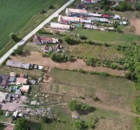 Aerial view of residential plots in the village of Rakytník, surrounded by greenery and houses.