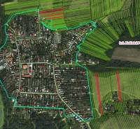 The village of Košická Polianka is surrounded by agricultural and forest lands with green and red areas.