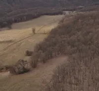 The landscape near Príbelce depicts agricultural and forest lands with scattered trees and dirt roads.