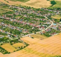 Aerial view of the landscape and gardens in the village of Dvorníky - Včeláre, surrounded by fields.