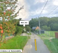 Access road to a family house in Kokava nad Rimavicou, surrounded by greenery and trees.