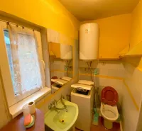 Bathroom in a family house with a sink, toilet, and heating boiler.