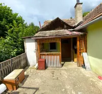 A family house in Kokava nad Rimavicou with a terrace, wooden railing, and surroundings full of greenery.