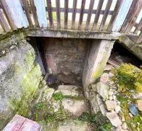 Entrance to the basement of a stone family house in Kokava nad Rimavicou with a wooden fence.
