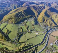 Aerial view of agricultural and forest land in Orovnica with a river and a highway.