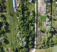Aerial view of gardens in Branč with a road and trees.