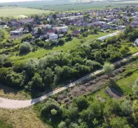Aerial view of gardens in the village of Branč with scattered houses and dense greenery.