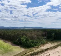 Landscape in Lozorno: Agricultural and forest land with fields and forests under a cloudy sky.