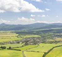 A view of agricultural and forest lands around Jablonové with mountains in the background.