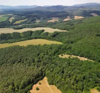 Aerial view of agricultural and forest land around Žitná - Radiša surrounded by forests and meadows.