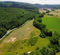 Aerial view of agricultural and forest land in Žitná - Radiša, surrounded by forests and a road.