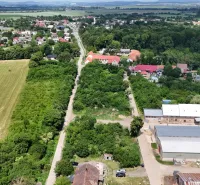 A view of residential plots in Parchovany, surrounded by greenery and buildings.