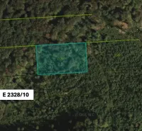 Aerial view of agricultural and forest land in Koňuš surrounded by dense forest.