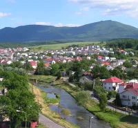 Panorama of Snina with a river, houses, and hills in the area of Special Properties.