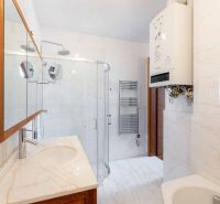 Bathroom in a 2-room apartment with a sink, shower, and water heating.