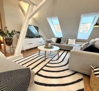 A bright living room with a sofa and a patterned carpet in a 4-room apartment.