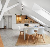 An attic kitchen in a 4-room apartment with modern appliances and a round table.