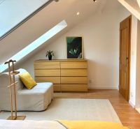 Attic room in a 4-room apartment with wooden decor and light furniture.