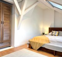 Bright bedroom in a 4-room apartment with a wooden wardrobe and a floor with a wooden decor.
