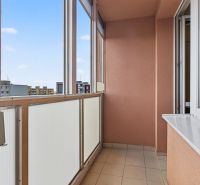 A glazed balcony with a view of the housing estate, part of a one-room apartment.