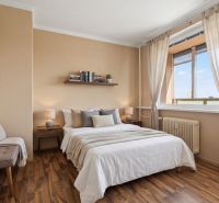 Bedroom with wood-decor flooring in a studio apartment, cozy interior with decorations.