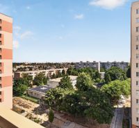 The view from the balcony of a one-room apartment on Jiráskova Street in Trnava, with blocks and greenery.
