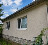 A family house in Veľké Ripňany with a gray facade and a stone plinth.