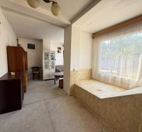 Living room in a family house with a large window and furniture.
