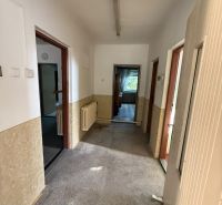 A hallway in a family house with a view into the rooms and radiators on the walls.