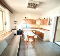 A kitchen in a family house with a wooden decor floor and simple furnishings.