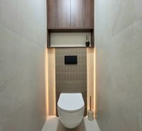 A toilet with a wooden decor and storage space in a 3-room apartment.