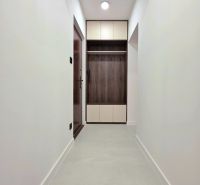 A hallway in a 3-room apartment with white walls and a floor with a wooden decor.