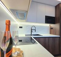 A kitchen in a 3-room apartment with a marble countertop and wine glasses.