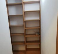 Storage space in a family house with wooden shelves and tiled floor.