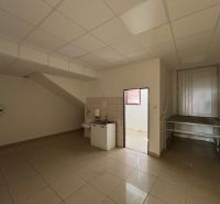 Interior of commercial premises with a sink, tiles, and entrance to another room.