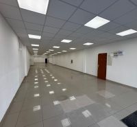 Spacious commercial spaces with white walls and shiny floors.