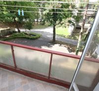 The view from the balcony of a 2-room apartment on Talichova Street in Bratislava - Dúbravka, overlooking a courtyard covered with trees.