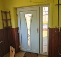 Entrance door in a family house with wooden paneling and tiled floor.