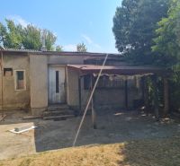 A family house in Komjatice with a neglected outdoor area and a shelter.