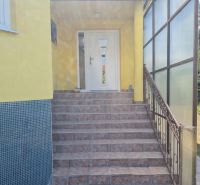 The entrance of the family house with stairs is surrounded by a garden in Komjatice.