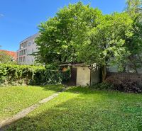 Garden in the Old Town of Bratislava on Krátka Street with a lawn and trees near a family house.