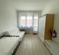 Living room in a 3-room apartment with light walls and a floor with a wood decor.