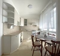 A kitchen in a 3-room apartment with a table and chairs, a floor with a wooden decor.