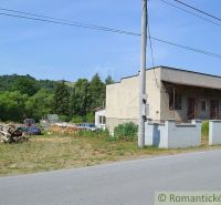 A family house in Varadka, by the main road, with wood and cars on the property.