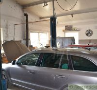 A car service in a family house with two vehicles being prepared for repair.